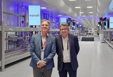 Two PM Group people standing in the Sanofi facility with modular equipment