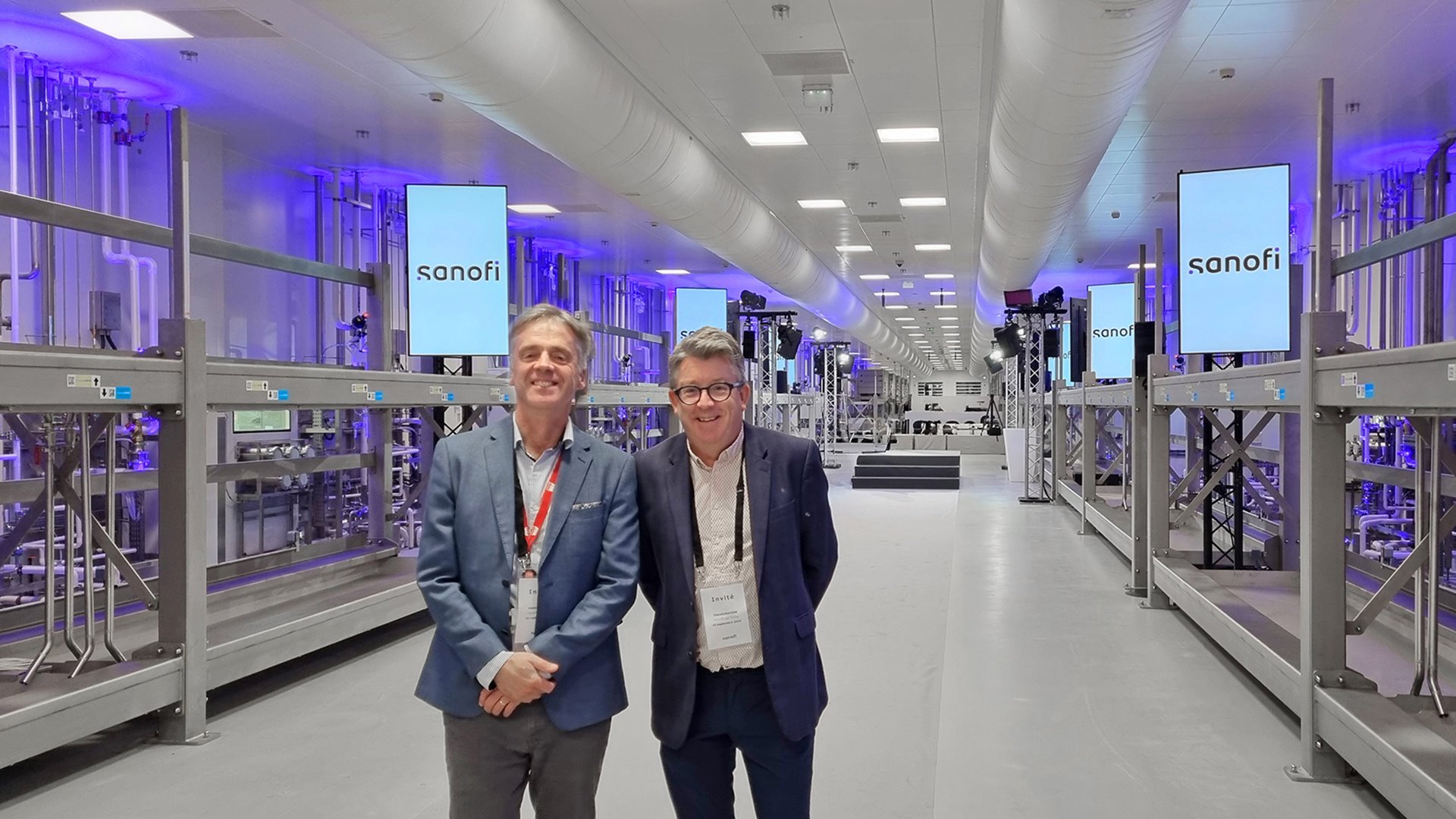 Two men pictured standing in a modular vaccine facility. 